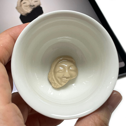 A porcelain cup with a smile on the face